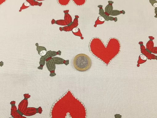 Weihnachtsstoff aus Baumwolle mit Strohmännchen Euro als Größenvergleich