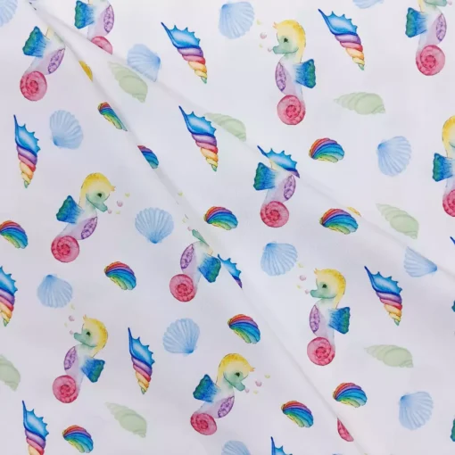 Stoff mit Seepferdchen und Muscheln in weiß mit Regenbogenfarben