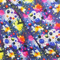 bunter Kinderstoff mit Klecksen in Falten gelegt